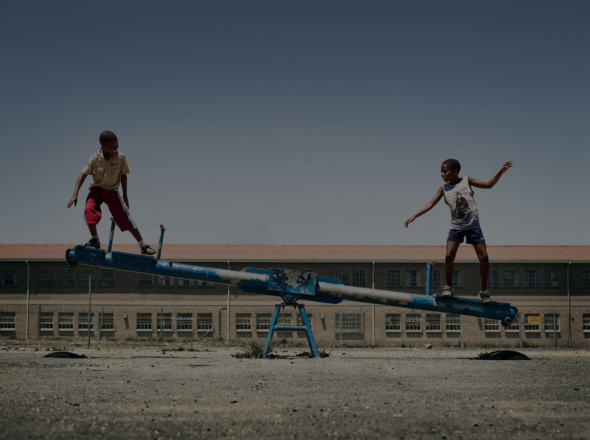 Two boys balancing on a seesaw
